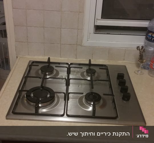 כיריים גז עם ארבעה מבערים וכפתורי שליטה